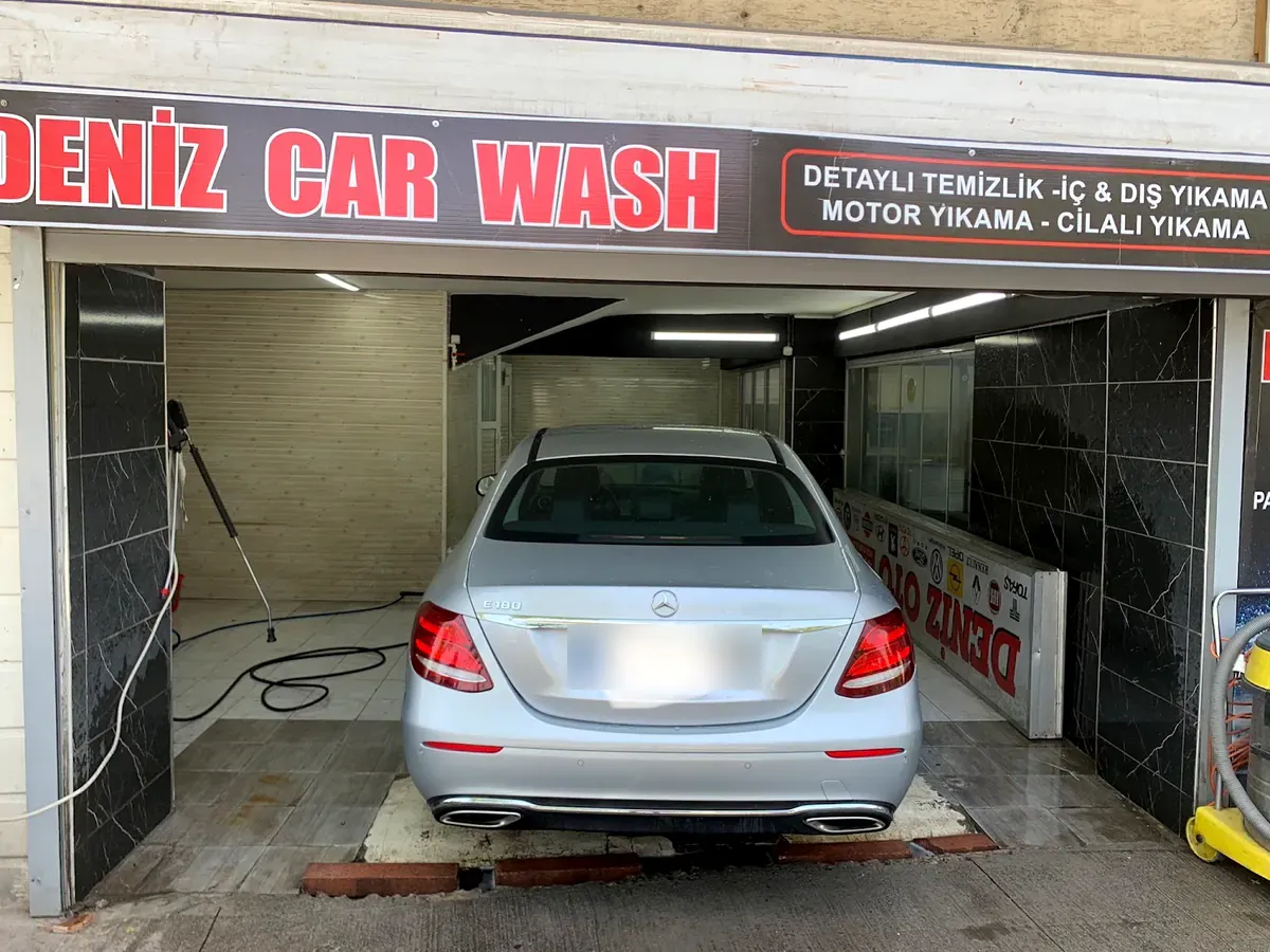 Deniz Car Wash yıkama peronunda yıkanan gümüş Mercedes, üstte kırmızı DENİZ CAR WASH tabelası